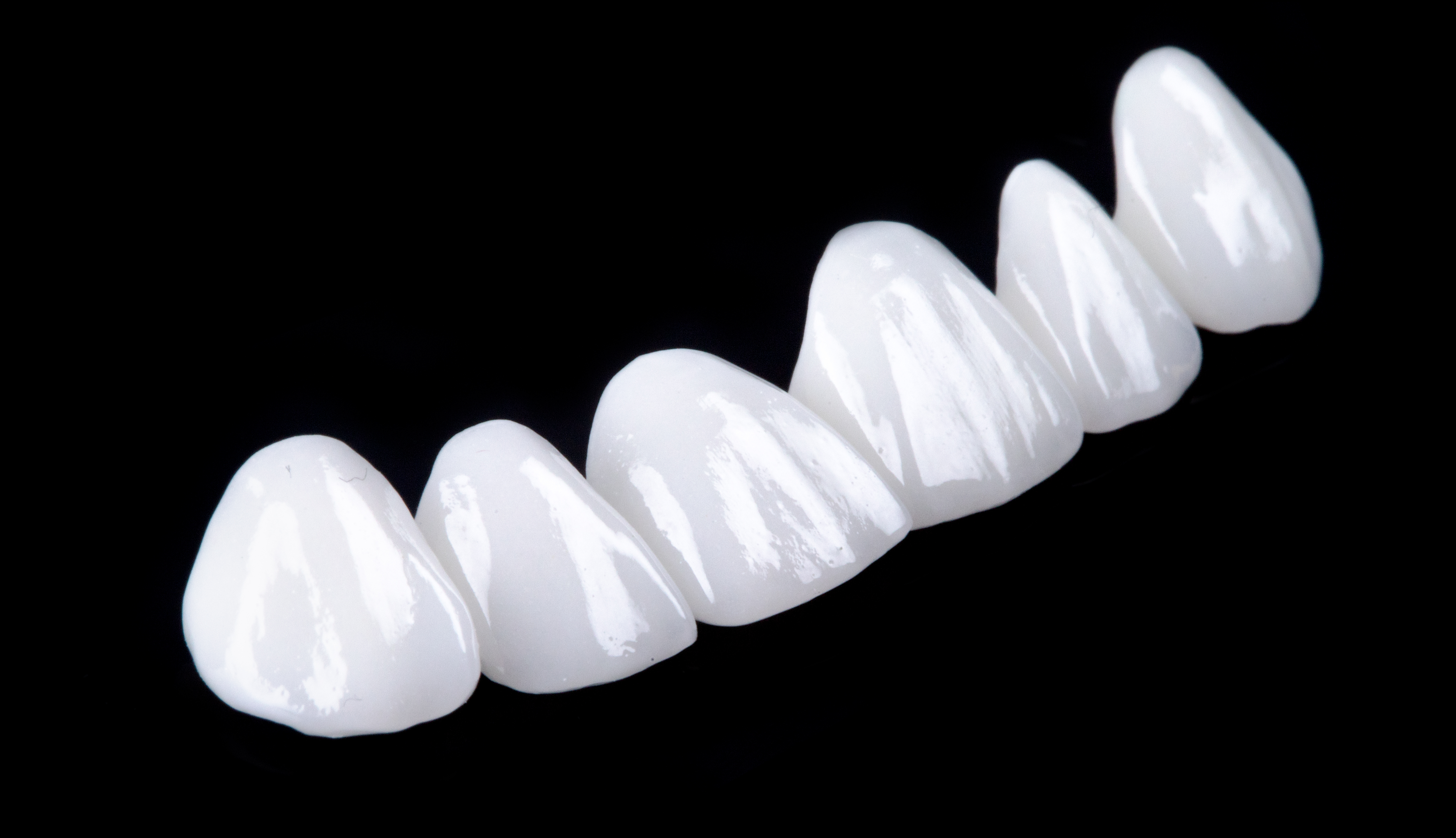 Ceramic,Dentures,And,Crowns,On,Black,Background.,Top,View,On
